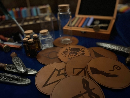 Bild föreställande underlägg i läder med olika inbrända tryck samt glasflaskor.